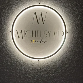 Illuminated circular Michelsy VIP Studio sign on a textured wall