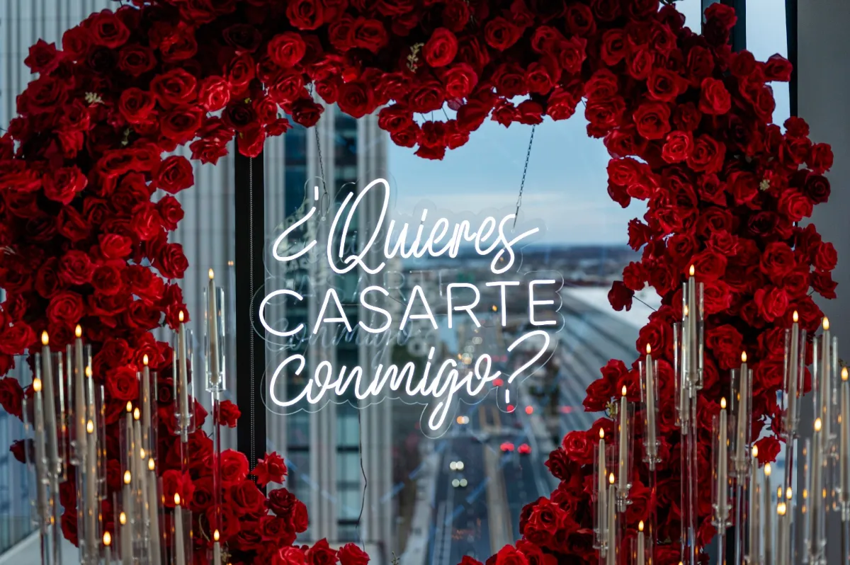 Proposal setup with a neon sign inside a wall of red roses
